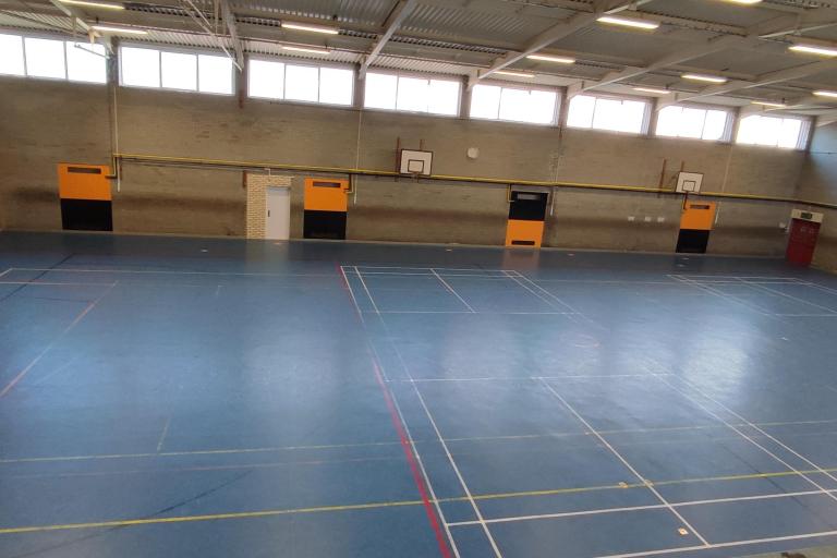Sports Hall at Grangetown Youth Centre. A large sports hall with two basketball fields and two handball gates perpendicular to the basketball fields.