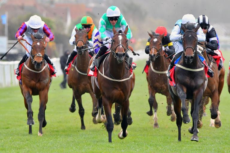 Front shot of horse riders during a competition.