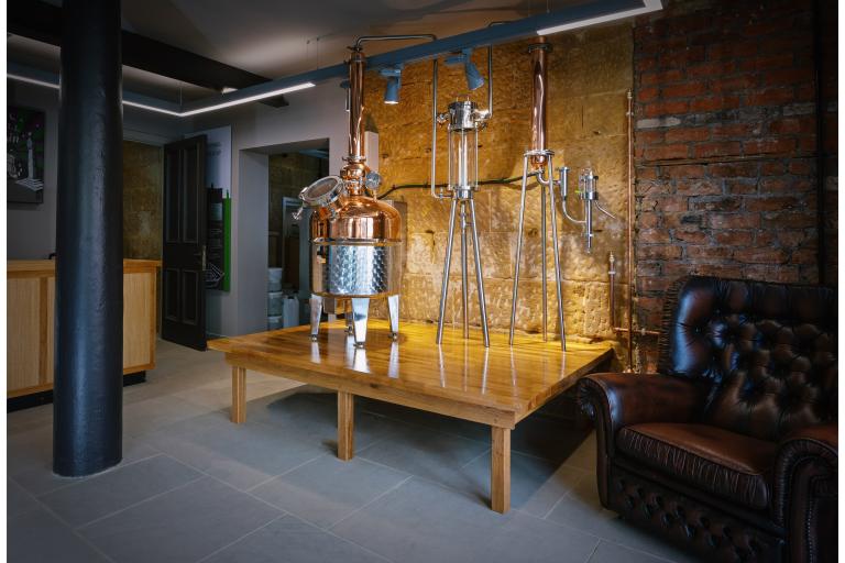 Image showing the interior of Shorty's Gins – a shop and award-winning distillery based in the Guisborough Town Hall. In the middle foreground there is a table with distillation equipment on it.  
