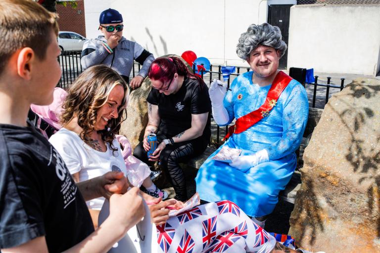 Man dressed like the Queen spending time with his family at the street party in Loftus.