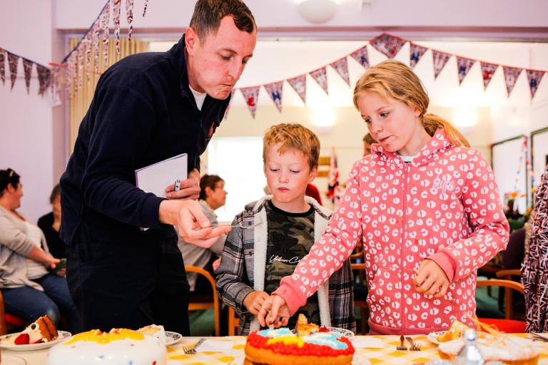 Family decorating a cake at the scarecrow festival in Liverston.