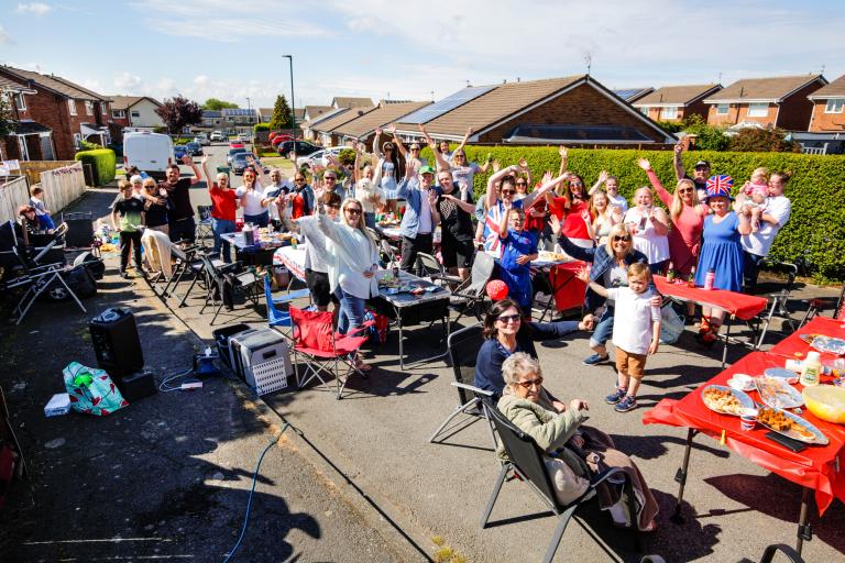 Lots of people posing for the picture with their hands raised at a street party in Eston.