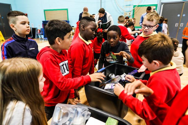 Pupils at South Bank Primary trying to sort out waste items into recyclable waste, general waste and green waste.