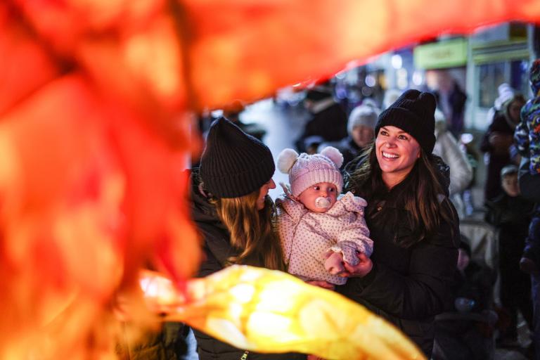 A mother and her baby admiring the Christmas parade