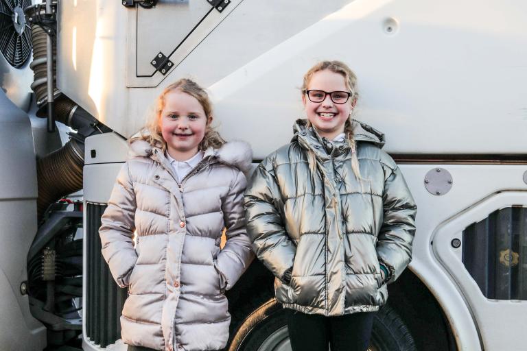 Image of two young girls with the street sweeper named by them as Clean-Up Clarence. 