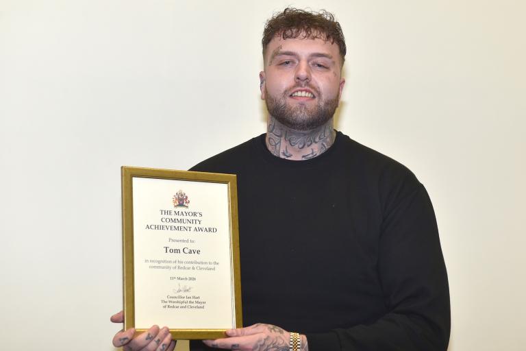 Tom holding his award