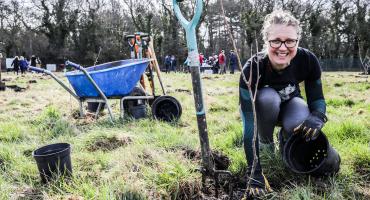 Lisa Haetzman, Climate Change and Sustainability Officer next to the tree she planted