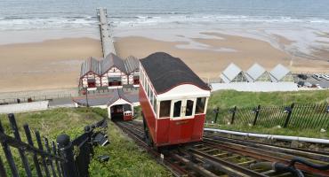 Picture of the Saltburn Tram going uphill with the Saltburn pear and the beach in the background