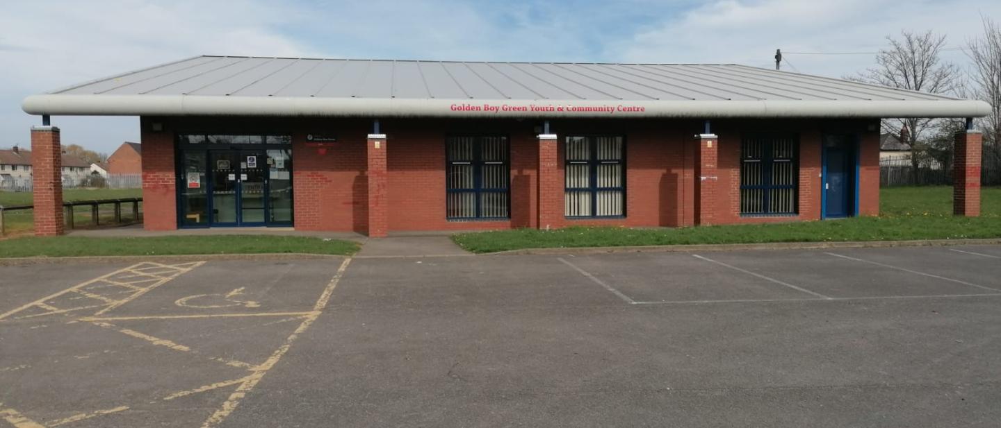 Image of the Golden Boy Green Youth and Community Centre from the front entrance with the car park