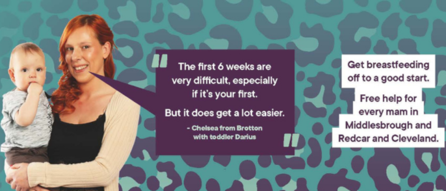 Woman holding her baby and smiling at the camera