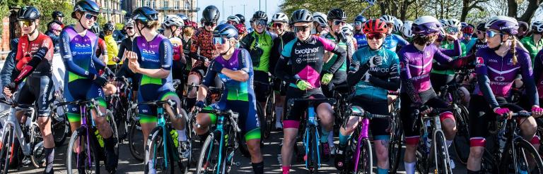Image of female cyclists at the start/finish line. They are wearing cycling clothing of various colours.