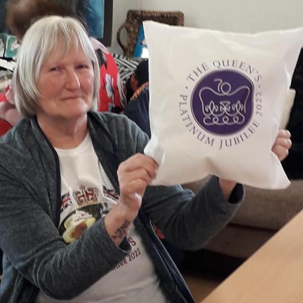 Woman showing her Jubilee themed pillow embroidery.