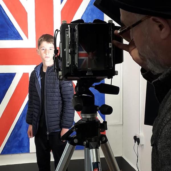 Photographer taking a Jubilee themed picture of a boy with the Great Britain flag behind him.