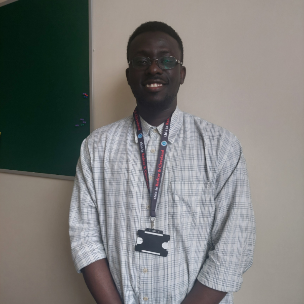 A young man in a white shirt smiling
